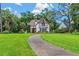 Picturesque Tudor-style home with a curving driveway and lush, green lawns at 9233 Silver Lake Dr, Leesburg, FL 34788