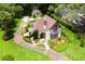 Elegant Tudor-style home featuring beautiful landscaping, a stone entrance, and a winding driveway at 9233 Silver Lake Dr, Leesburg, FL 34788