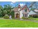 Charming Tudor home with manicured lawn, blooming landscaping and a stone facade at 9233 Silver Lake Dr, Leesburg, FL 34788