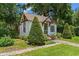 Charming cottage-style home featuring a steeply pitched roof and lush landscaping at 9233 Silver Lake Dr, Leesburg, FL 34788