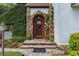 Charming home featuring a stone archway, a wooden front door with glass, and surrounding lush landscaping at 9233 Silver Lake Dr, Leesburg, FL 34788
