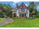 Stunning Tudor-style home with stone accents, lush landscaping, and a charming front entrance at 9233 Silver Lake Dr, Leesburg, FL 34788