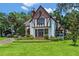Beautiful Tudor home featuring a stone facade, manicured landscaping, and a well-maintained lawn at 9233 Silver Lake Dr, Leesburg, FL 34788