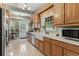 Bright kitchen with white tiled floors, modern appliances, and light wood cabinets at 9233 Silver Lake Dr, Leesburg, FL 34788