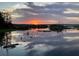Tranquil lake reflecting a vibrant sunset, with wetland vegetation and scattered islands dotting the horizon at 9233 Silver Lake Dr, Leesburg, FL 34788