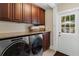 Modern laundry room with front-load washer and dryer, granite countertop and exterior door at 9233 Silver Lake Dr, Leesburg, FL 34788