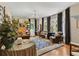 Elegant living room with hardwood floors, a vintage chandelier, large windows, and cozy seating at 9233 Silver Lake Dr, Leesburg, FL 34788