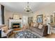 Bright living room with a fireplace, hardwood floors, a chandelier, and comfortable seating arrangements at 9233 Silver Lake Dr, Leesburg, FL 34788
