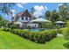 Inviting pool area surrounded by a manicured lawn, mature landscaping, and an iron fence at 9233 Silver Lake Dr, Leesburg, FL 34788