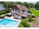 Backyard pool area featuring a sparkling pool, patio furniture, and lush landscaping at 9233 Silver Lake Dr, Leesburg, FL 34788