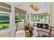 Sunroom featuring multiple windows with lovely outdoor views, seating and dog kennels at 9233 Silver Lake Dr, Leesburg, FL 34788