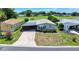 A high-angle view shows the house with a screened-in porch and car port, complemented by lush landscaping and verdant lawn at 926 Saint Andrews Blvd, Lady Lake, FL 32159