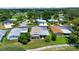 An aerial view of the property displaying a charming home with a well-manicured lawn, driveway and scenic neighborhood at 926 Saint Andrews Blvd, Lady Lake, FL 32159