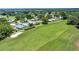 An aerial shot displays a vast golf course surrounded by charming homes and lush trees at 926 Saint Andrews Blvd, Lady Lake, FL 32159