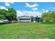 Large backyard showcasing well-maintained lawn, mature trees, and a screened in patio, ideal for outdoor living at 926 Saint Andrews Blvd, Lady Lake, FL 32159