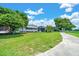 A beautiful backyard features lush green lawn and mature trees providing ample shade and an open view of the property at 926 Saint Andrews Blvd, Lady Lake, FL 32159