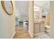 A bright bathroom with stone countertops, cabinet storage, and a view into the living area at 926 Saint Andrews Blvd, Lady Lake, FL 32159
