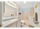 Well-lit bathroom with a granite countertop, grey cabinets, and a shower-tub with curtain at 926 Saint Andrews Blvd, Lady Lake, FL 32159