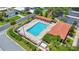 An aerial view of a community pool featuring lounge chairs, shade and lush landscaping for outdoor relaxation at 926 Saint Andrews Blvd, Lady Lake, FL 32159