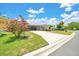 Charming home featuring a long driveway, covered carport, and mature landscaping with a beautiful crape myrtle tree at 926 Saint Andrews Blvd, Lady Lake, FL 32159