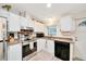 Cozy kitchen featuring updated appliances, light countertops, and ample white cabinetry at 926 Saint Andrews Blvd, Lady Lake, FL 32159