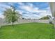 Lush backyard featuring a well-maintained lawn, privacy fence, and a mature tree adding natural charm at 9380 La Salle St, Groveland, FL 34736