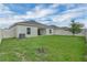 Enjoy a relaxing view of the backyard featuring lush green grass, a patio, white fencing, and a tree at 9380 La Salle St, Groveland, FL 34736