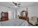 Bright bedroom features a four-poster bed, dresser with mirror, and chair, with a view into the hallway at 9380 La Salle St, Groveland, FL 34736