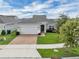 Charming single-story home with a brick driveway, a two-car garage, and a well maintained green lawn at 9380 La Salle St, Groveland, FL 34736