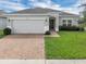 Well-maintained single-story home featuring a brick-paved walkway and lush green lawn at 9380 La Salle St, Groveland, FL 34736