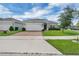 Charming single-story home with a brick-paved driveway and well-manicured lawn at 9380 La Salle St, Groveland, FL 34736