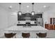 Modern kitchen featuring black cabinets, stainless steel appliances, and a large island at 9380 La Salle St, Groveland, FL 34736