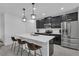 Bright modern kitchen with black cabinetry, stainless steel appliances, and island seating at 9380 La Salle St, Groveland, FL 34736