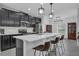 Modern kitchen features sleek, black cabinets, stainless steel appliances, and a spacious white quartz island with bar seating at 9380 La Salle St, Groveland, FL 34736