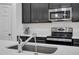 Modern kitchen features stainless steel appliances, black cabinetry, and a chrome faucet at 9380 La Salle St, Groveland, FL 34736