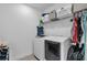 Modern laundry room featuring new washer and dryer with storage shelf at 9380 La Salle St, Groveland, FL 34736