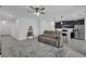 Cozy living room features a comfortable sectional sofa, stylish shelving, and a view into the modern kitchen with bar seating at 9380 La Salle St, Groveland, FL 34736