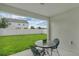 Covered patio with table and chairs overlooking the lawn and white fence, with neighborhood homes visible at 9380 La Salle St, Groveland, FL 34736