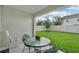 Covered patio showcasing a table, chairs, and rocking chair with a view of the lush green lawn at 9380 La Salle St, Groveland, FL 34736