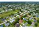 An aerial shot captures an expansive neighborhood with homes nestled among mature trees and a nearby golf course at 9790 Se 175Th St, Summerfield, FL 34491