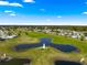 Sprawling aerial view highlighting the golf course and surrounding residential neighborhood with picturesque ponds at 9790 Se 175Th St, Summerfield, FL 34491