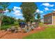 Backyard patio sitting area with cozy wicker furniture and manicured landscaping for relaxation and enjoyment at 9790 Se 175Th St, Summerfield, FL 34491
