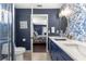 Bathroom showcases a double sink vanity, blue floral wallpaper, and a glass-enclosed shower at 9790 Se 175Th St, Summerfield, FL 34491