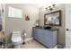 Bathroom featuring a unique vessel sink, blue vanity, and decorative mirror at 9790 Se 175Th St, Summerfield, FL 34491