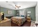 Spacious bedroom with ceiling fan, windows, wood-look floors, and green walls at 9790 Se 175Th St, Summerfield, FL 34491