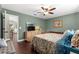Cozy bedroom with green walls, ceiling fan, and wood-look flooring at 9790 Se 175Th St, Summerfield, FL 34491