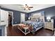 Spacious bedroom with dark blue walls, a walk-in closet, and coordinating blue and white bedding at 9790 Se 175Th St, Summerfield, FL 34491