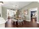 Bright dining room with modern light fixture, seating for six, and dark hardwood flooring at 9790 Se 175Th St, Summerfield, FL 34491