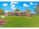 Beautiful home featuring a well-kept lawn, complemented by a clear blue sky with scattered clouds on a sunny day at 9790 Se 175Th St, Summerfield, FL 34491