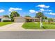 Charming single-story home with a well-manicured lawn and two-car garage, set against a backdrop of blue skies and fluffy clouds at 9790 Se 175Th St, Summerfield, FL 34491
